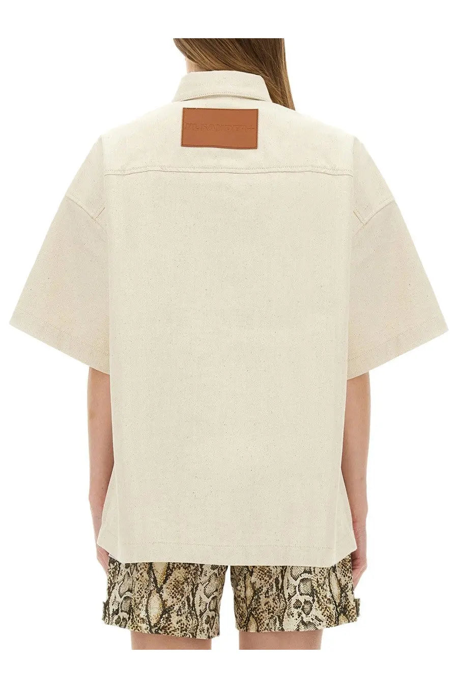 Cream-colored jil sander women’s heavy cotton shirt with brown leather patch at the collar