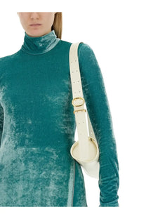 A cream-colored leather shoulder bag with gold-tone buckle and adjustable strap paired with jil sander blue top