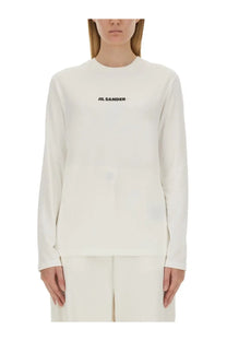 Cream-colored long-sleeved cotton top with black jil sander logo printed across the chest for women