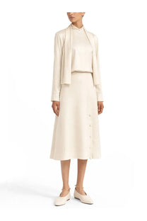 Cream-colored silk midi skirt with button-front detail and soft flowing silhouette paired with jil sander white shirt