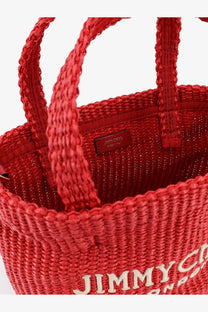 Red jimmy choo women’s raffia crossbody bag with braided handles and bold logo on front