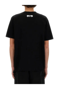 Back view of a black junya watanabe man short-sleeved t-shirt with a white oyo logo printed at the center