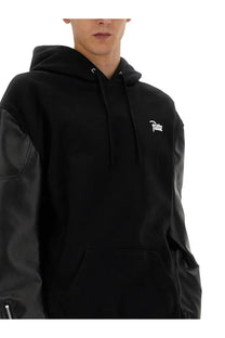 Black patta hoodie with contrasting leather sleeves and white embroidered logo on chest by junya watanabe man