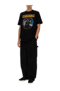 Black short-sleeved junya watanabe man t-shirt featuring vibrant scorpions graphic in blue white and gold with yellow lettering