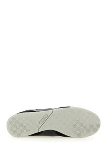 Back view of Junya Watanabe Man men’s black athletic sneaker with white rubber sole and reebok logo on heel