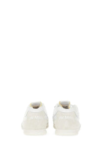 Back view of white suede low-top junya watanabe man sneaker with subtle maison margiela logo on the heel