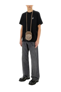 Beige circular crossbody bag with textured fabric finish and adjustable strap paired with jw anderson men’s anchor shirt black