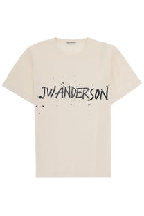 Cream-colored cotton jw anderson men shirt with bold black logo and splatter paint effect on the chest