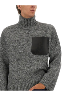 Jw anderson men’s gray textured turtleneck sweater with black leather patch pocket front view