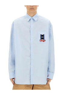 Light blue jw anderson men’s window shirt featuring a patch pocket embroidered with roses and text