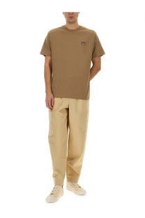 Tan short-sleeved t-shirt with small embroidered fox logo paired with kenzo men’s beige cargo jogging pants