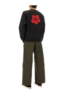 Back view of kenzo men’s classic black sweatshirt with bold red embroidered flower on soft cotton fabric