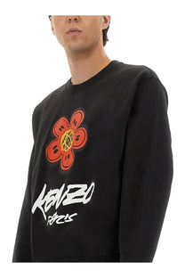 Kenzo men’s cotton sweatshirt in black featuring a bold orange flower graphic with yellow center and white kenzo paris text