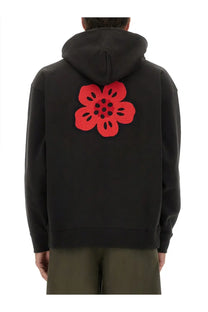 Back side of kenzo men’s black hoodie featuring a bold red embroidered flower on the cotton fabric