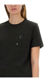 Kenzo women’s black cotton t-shirt with a small chest pocket featuring a white embroidered clover design