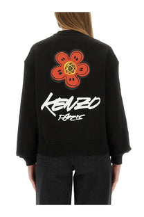 Back view of kenzo women’s future black sweatshirt with bold orange flower patch and white kenzo paris lettering