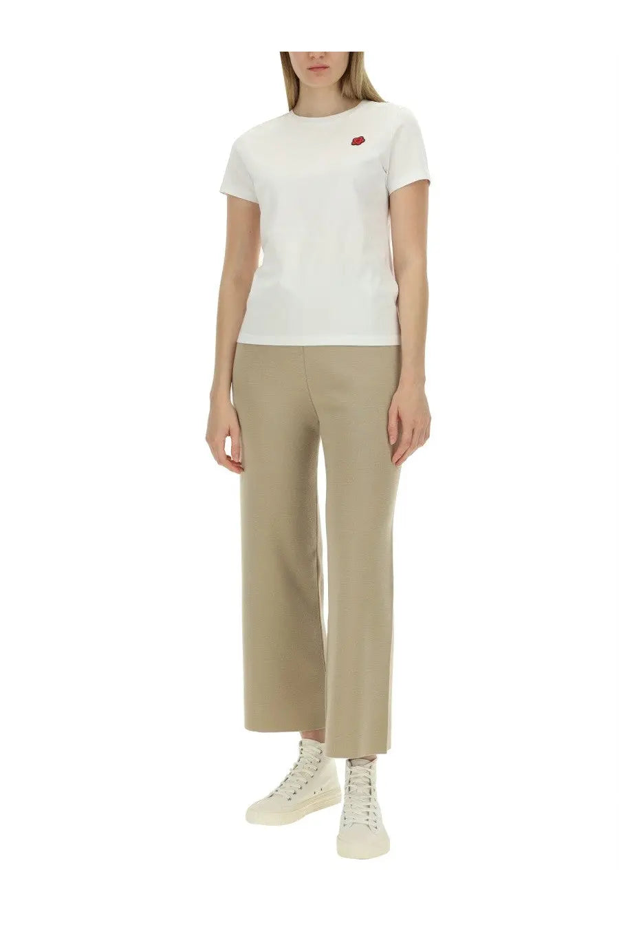 White short-sleeved t-shirt with small red embroidered apple on left chest paired with kenzo women beige pants