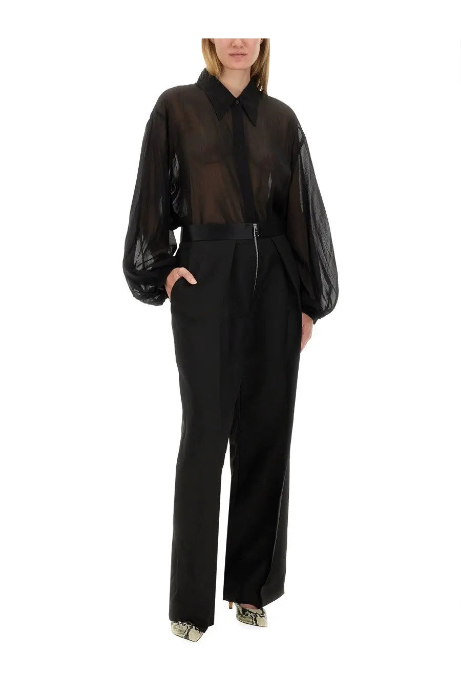 Khaite women’s pants the marine black paired with a black sheer blouse featuring voluminous sleeves and a structured collar