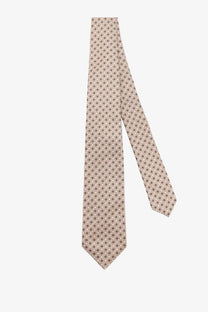 A beige Kiton men’s silk tie with a subtle pattern of small gray and black geometric shapes