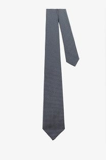 A navy blue Kiton men’s silk tie with a subtle white dot pattern made from smooth silk fabric