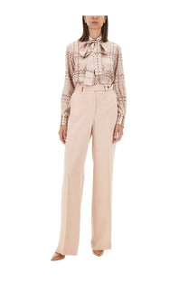 Beige silk blouse with geometric pattern and tied neck detail paired with kiton women’s blue satin pants