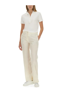 Cream-colored wide-leg trousers with a clean tailored fit paired with Lacoste women’s white polo shirt
