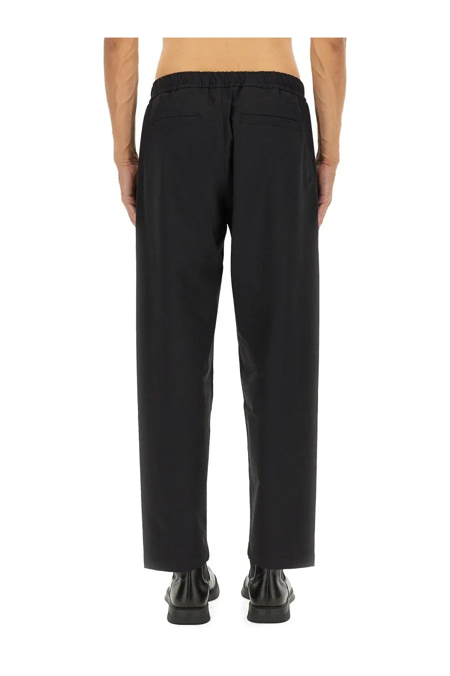 Back view of laminar men’s comfort tech black tapered trousers with elastic waistband and two rear pockets