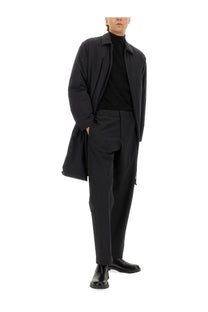 Black trench coat with structured collar and subtle seam detailing paired with laminar men’s comfort tech pants black