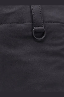 Black nylon bag with matching leather strap and metal ring shown with laminar men’s technical fabric trousers black