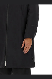 Black trench coat with sleek minimalist design and subtle sleeve branding laminar men’s waterproof goretex two layer