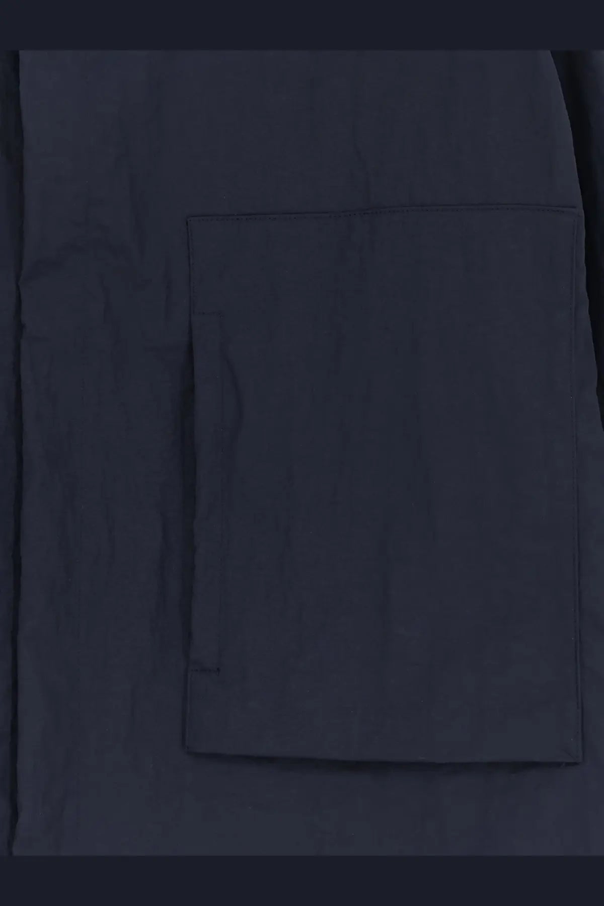 Dark navy fabric pocket with subtle texture and stitched edges on laminar men’s wrinkled nylon jacket blue