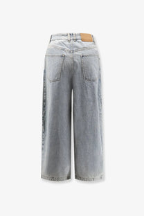 Back view of lamrons women’s balloon fit light-wash denim wide-leg jeans with classic pockets and tan leather patch