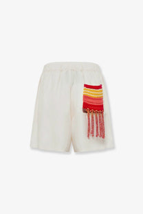 Laneus women’s viscose and linen blend cream shorts with vibrant hand-knitted red and yellow patch and tassels