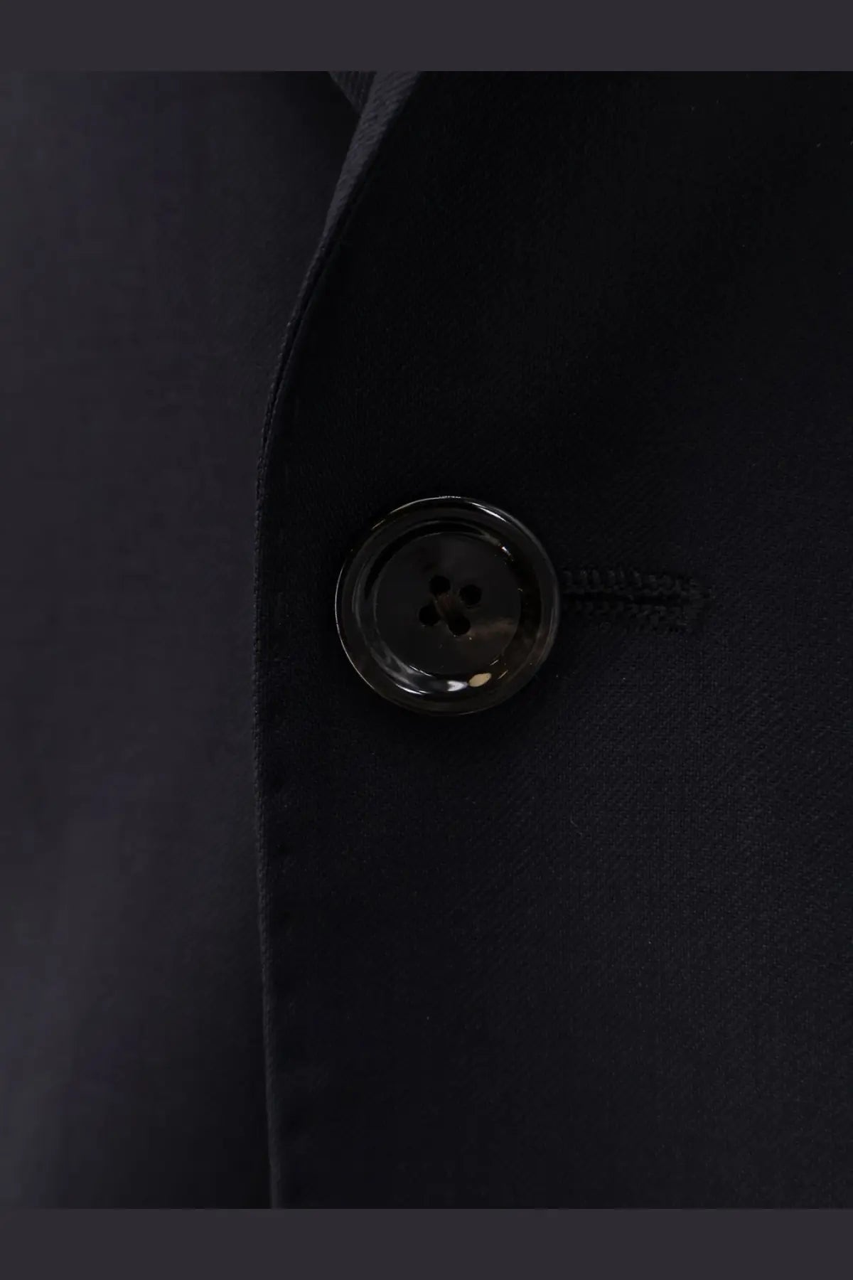Black glossy four-hole button set into dark fabric on lardini men’s iconic single breasted pure virgin wool blue suit