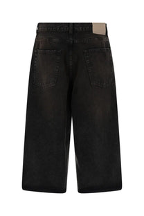 Black denim Our Legacy men’s capri cut shorts with a faded distressed finish and classic back pockets shown from the back