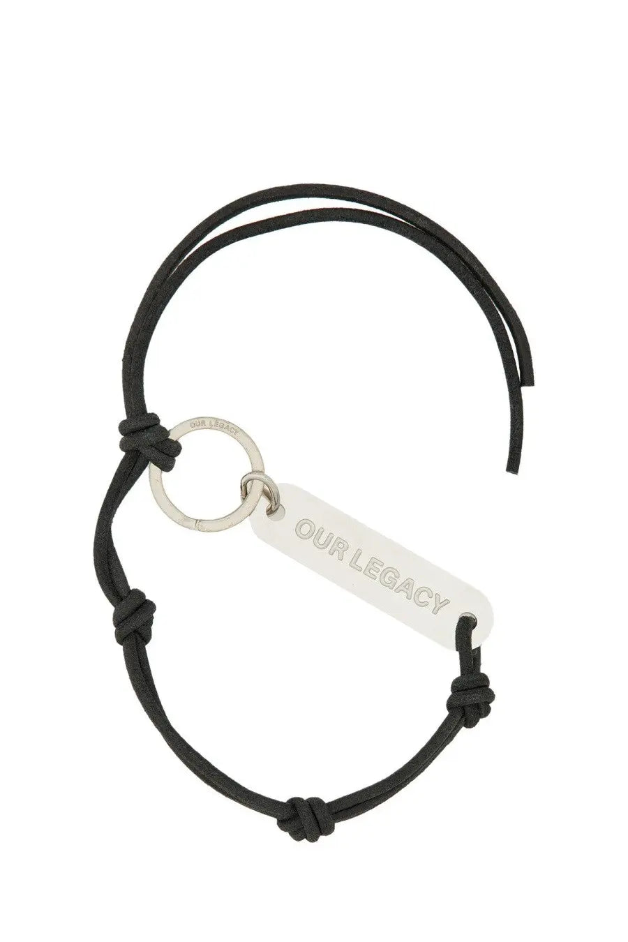 Our Legacy men’s black leather keychain with a black cord bracelet and silver-toned engraved rectangular tag