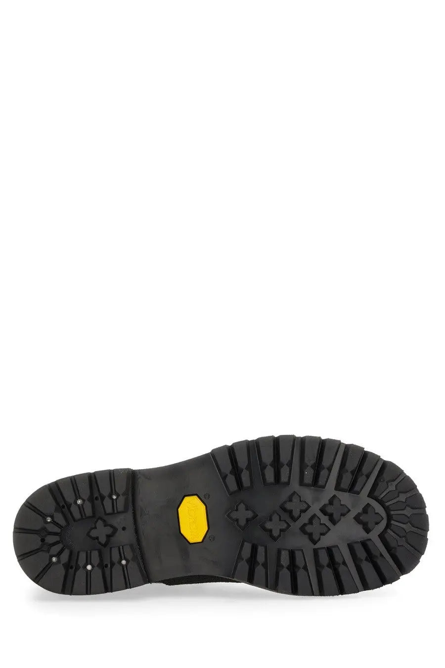Black rubber sole of our legacy men’s leather quest shoe brown with yellow vibram logo and intricate tread pattern