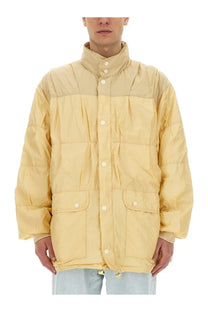 Our Legacy men’s beige nylon jacket with a pale yellow quilted puffer design high collar and white buttons