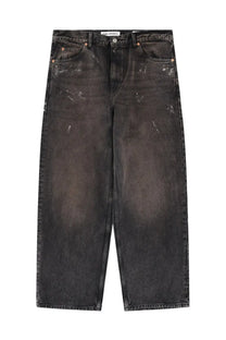 Our legacy men’s vast cut jeans black distressed denim with faded paint splatter and copper rivets front view