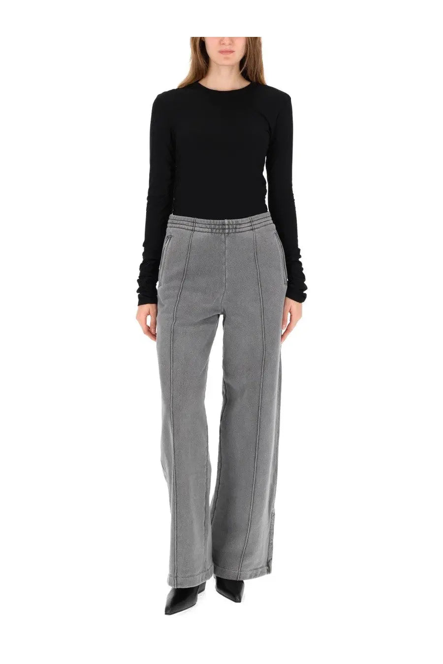 Gray wide-leg trousers with vertical seam detailing paired with Our Legacy women’s black long sleeve shirt