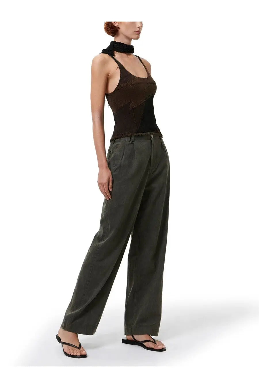 A model wears our legacy women’s top solo brown black sheer mesh tank top with high neckline and olive green trousers