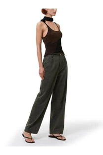 A model wears our legacy women’s top solo brown black sheer mesh tank top with high neckline and olive green trousers
