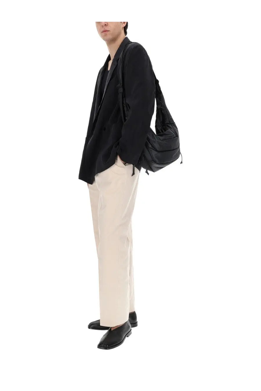 Black nylon shoulder bag with drawstring closure and adjustable strap featured alongside lemaire men’s silk double breasted blazer black