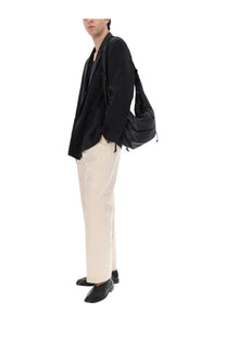 Black nylon shoulder bag with drawstring closure and adjustable strap featured alongside lemaire men’s silk double breasted blazer black