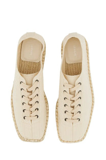 Cream-colored lemaire women’s espadrille sneakers with woven jute soles and black eyelets in linoleum white