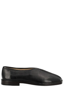 Lemaire women’s black leather moccasin with minimalist design and low block heel flat piped slipper