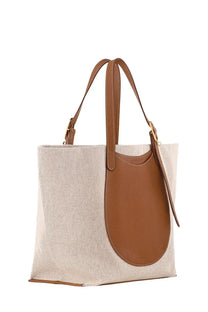 Beige canvas Longchamp women’s accomplice shopping bag with brown leather accents and handles for everyday use