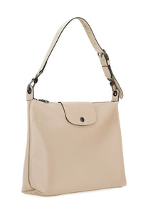 Beige leather Longchamp women’s borsa hobo le pliage handbag with minimalist design and black hardware accents