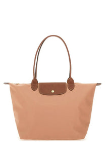 Beige Longchamp Le Pliage tote bag with brown leather handles and flap closure from Longchamp women’s collection