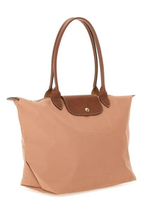 Beige longchamp le pliage tote bag with brown leather handles and textured flap closure in large size